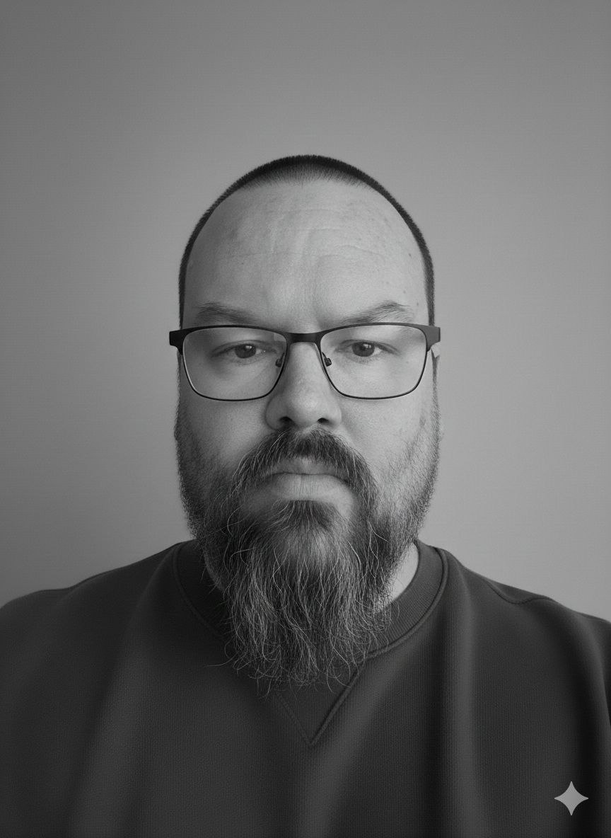 Black and white portrait of Anders Benke with short hair, glasses, and a long goatee.